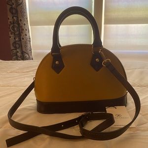 NWT two way leather handbag. Two tone yellow gold and brown coloring.